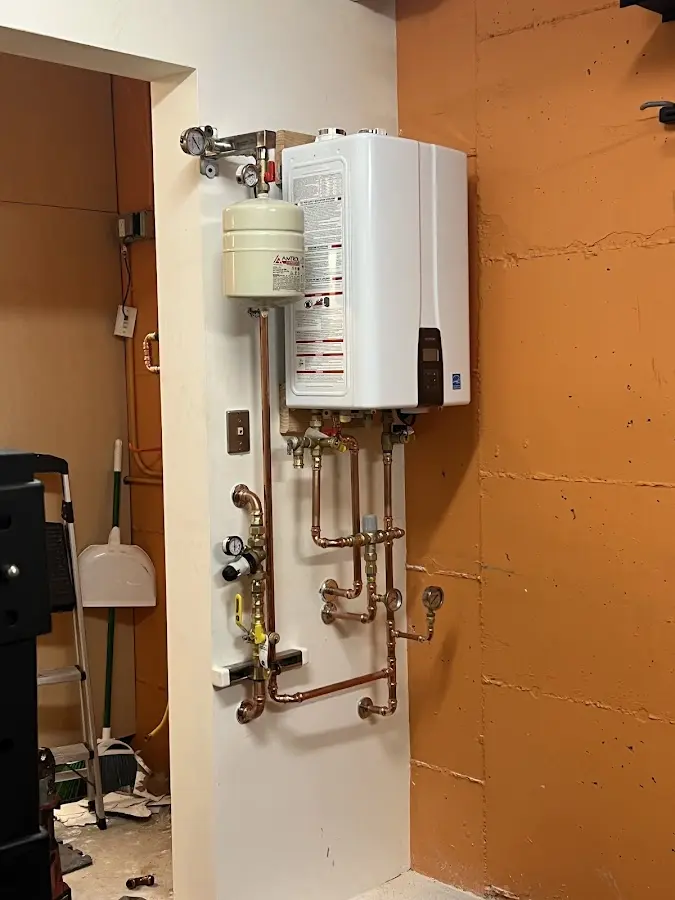 Plumbing technician inspecting water heater connections in Larkfield-Wikiup